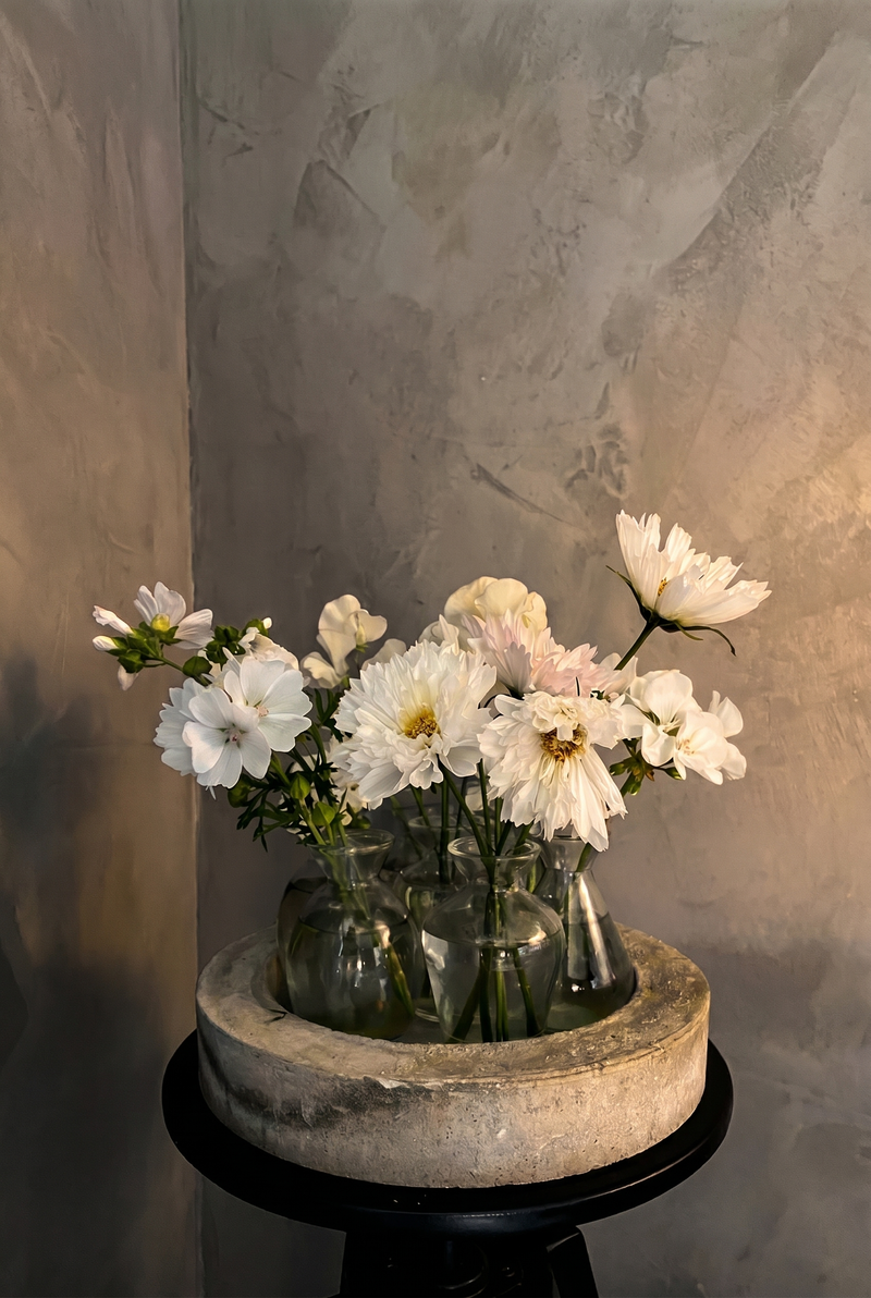 Vägg i Gråbeige microcement – blombukett, betongfat, pelare