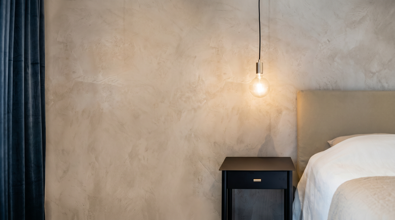 Vägg i Gråbeige microcement – sovrum, pendellampa, bred