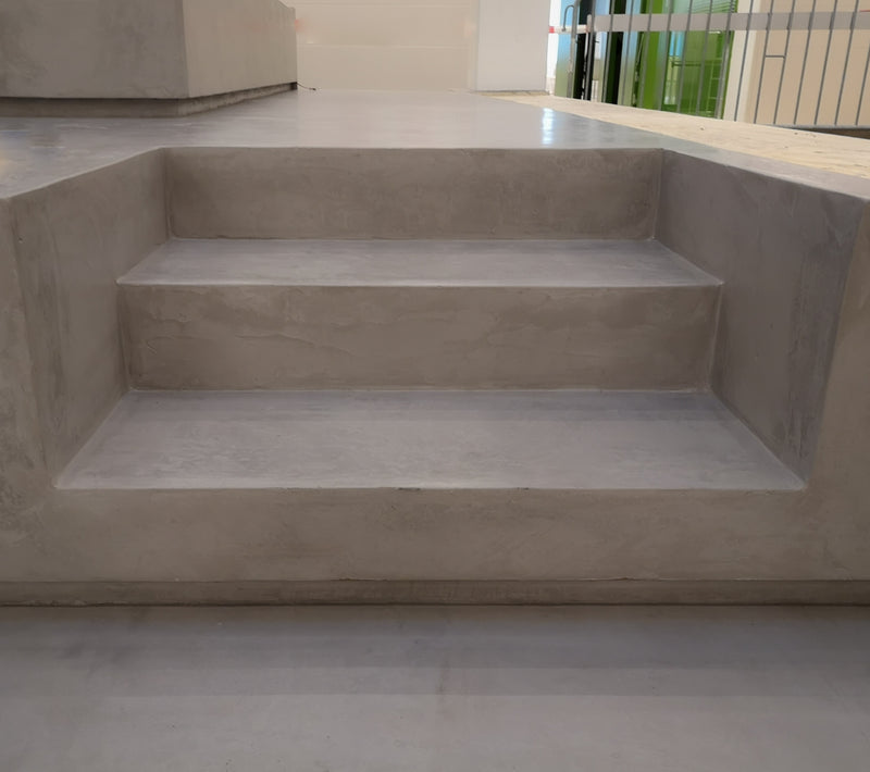 Golv i ljusgrå microcement – trappa, ljust ljusinsläpp, detalj