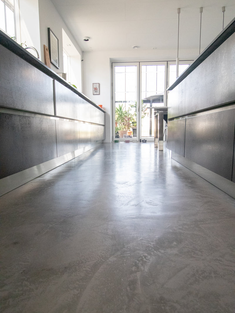 Golv i ljusgrå microcement – korridor, glaspartier, kontorsmiljö