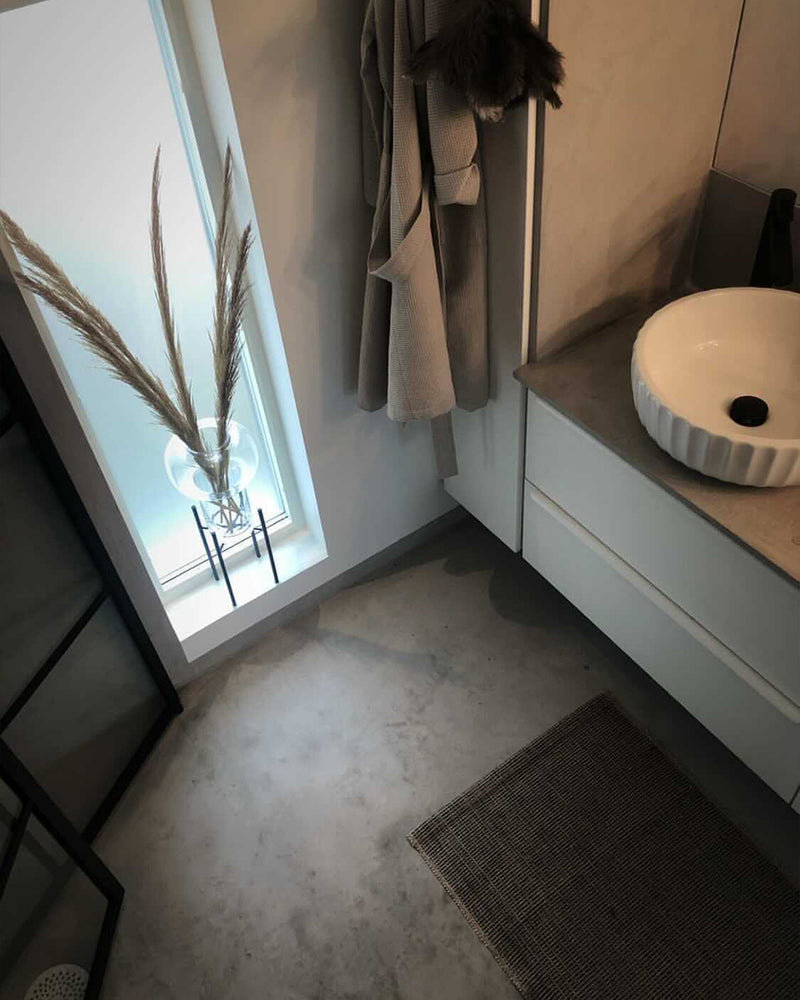 Golv i ljusgrå microcement – tvättställ