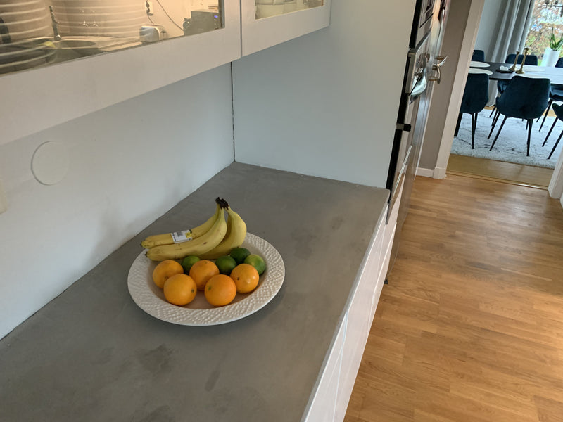 Bänkskiva i ljusgrå microcement – frukt, fönster