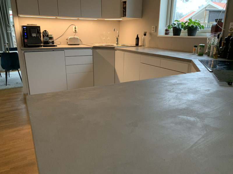 Bänkskiva i ljusgrå microcement – diskbänk, fönster