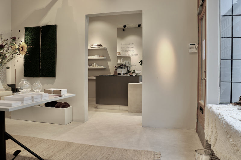 Interiör i gråbeige microcement – butiksmiljö, disk, kassa